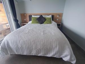 a bedroom with a white bed with green pillows at Carefree Apartments in Ulcinj +136 photos