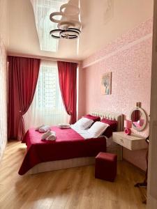 a bedroom with a red bed and a window at Panorama City View Apartment in Tbilisi City
