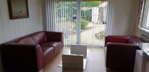 a living room with two leather couches and a large window at Chalet J151 in Heel