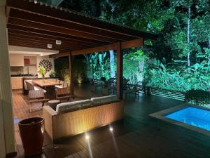 an outdoor patio with a swimming pool and a table at Exclusiva Casa 18G em Juqueí em Condomínio Resort de Luxo in Juquei