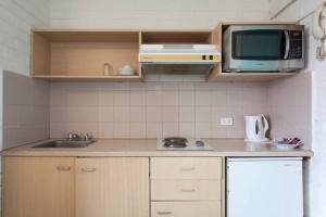 a kitchen with a sink and a microwave at H & D Apartments in Melbourne