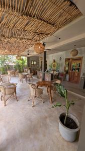 a living room with tables and chairs and a plant at Hotelito Sri Lanka in Weligama