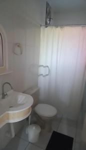 a white bathroom with a sink and a toilet at Pousada Astúrias in Ilha Comprida +31 photos