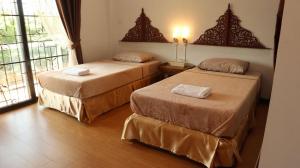 a room with two beds and a window at Tahnboon-ทานบุณ in Ban Mae