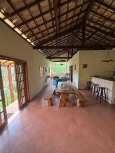 una stanza con panche e tavoli in legno in un edificio di Pé de montanha - Casa de campo a Brumadinho