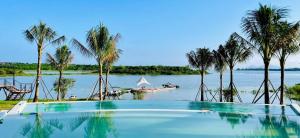 a swimming pool on a river with a boat in the water at The Lake House Retreat & Watersports in Tân Phú