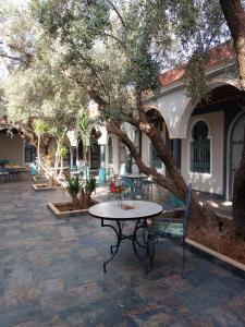 a patio with a table and chairs under a tree at Dar HISANE in Marrakesh