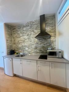 a kitchen with a sink and a microwave at Alcazar Suites in Jerez de la Frontera