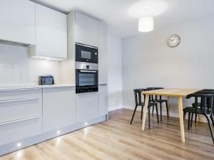une cuisine et une salle à manger avec une table et des chaises dans l'établissement Beautiful City Centre Apartment, à Belfast