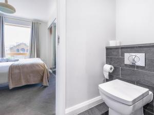 une salle de bain avec un lit et des toilettes dans une chambre dans l'établissement Beautiful City Centre Apartment, à Belfast