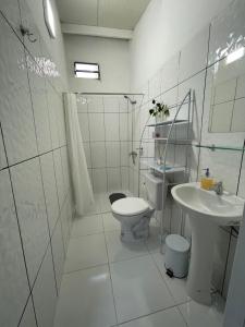 カアクペにあるHospedaje Tolaのトイレと洗面台を備えた白いバスルーム