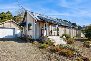 a small wooden house with a garage at Calm Waters in Rockaway Beach