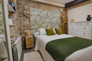 Un dormitorio con una cama y una pared de piedra. en Alameda de Santo Domingo, en Tui