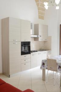 a kitchen with white cabinets and a stove top oven at Trilogia Salentina x AP Apartment in Gallipoli +39 photos