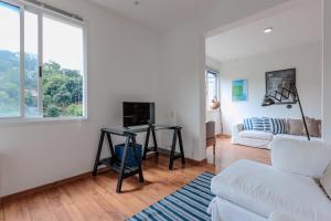 a living room with a white couch and a fireplace at Vista Carioca in Rio de Janeiro