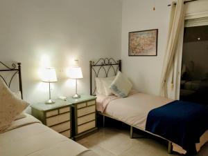 a bedroom with two beds and two lamps on tables at Villa Tranquilla in Estepona +37 photos