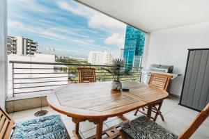 Una mesa y sillas en un balcón con vista a una ciudad. en Self-Check-In, Restaurants, Cafe's, Pubs, Work or Vacay, en Ciudad del Cabo