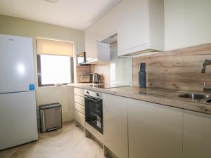 a kitchen with white cabinets and a sink at Marine Court Three Bedroom Second-floor Apartment 32 in Littlehampton +27 photos