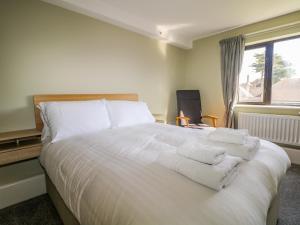 a bedroom with a white bed with towels on it at Marine Court Three Bedroom Second-floor Apartment 32 in Littlehampton