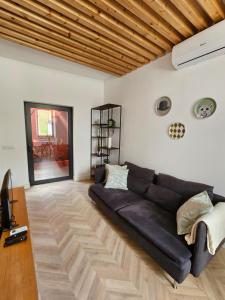 a living room with a black couch and a wooden ceiling at City Center Terrace in Faro +32 photos