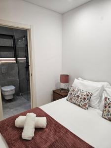 a bedroom with a white bed with towels on it at City Center Terrace in Faro