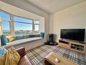 a living room with a couch and a flat screen tv at Lagoon View - Sea View- Pet Friendly - 2 Bed Apt - En-suite in Trearddur