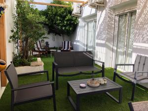 a patio with chairs and a table on the grass at Villa Tranquilla in Estepona