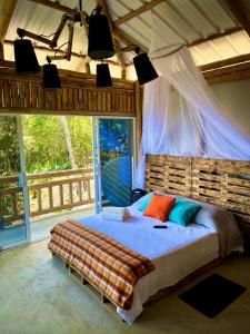 FloridaにあるParaiso Escondido glampingの大きなベッドと大きな窓のある寝室