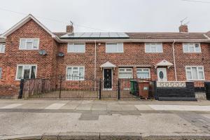 a red brick house with a solar roof at Henry House in Hartlepool