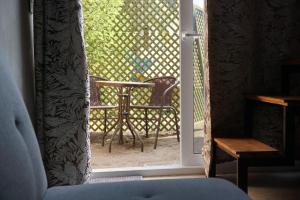 an open door with a table and a chair outside at Green Belly Surf Hostel in El Paredón Buena Vista