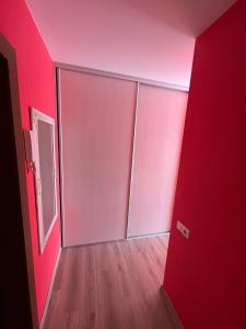 an empty room with pink walls and a door at LuXury Apartment on Naujakiemis Street in Klaipėda