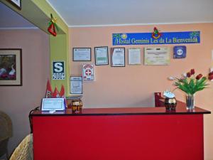 un mostrador rojo en una habitación con un cartel en la pared en Hostal Geminis en Ica