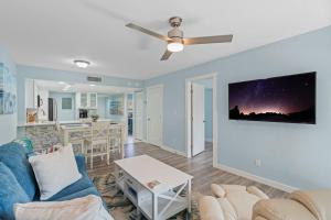 a living room with a couch and a ceiling fan at Luxury With Private Lanai Views and Close to the Pool in Naples
