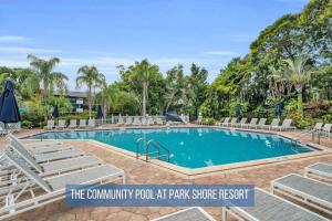 a swimming pool with lounge chairs and a resort at Luxury With Private Lanai Views and Close to the Pool in Naples
