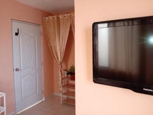 a television hanging on a wall in a room at Dona Beba Guesthouse in La Caleta