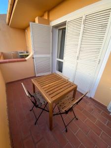 a wooden table and a chair on a patio at Il Mamuthones in Badesi