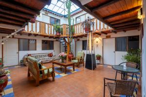 a living room with a balcony and a table and chairs at Hostal Teatro Inka in Cusco
