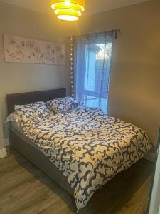 a bedroom with a bed with a comforter and a window at Fully refurbished house Belfast in Belfast