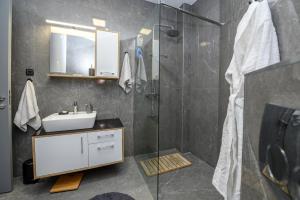 ein Badezimmer mit Waschbecken und Glasdusche in der Unterkunft Sea View Lux Apartment-Ancora Residence in Dobrota + 29 Fotos