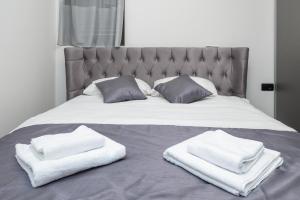 ein Bett mit zwei weißen Handtüchern darauf in der Unterkunft Sea View Lux Apartment-Ancora Residence in Dobrota