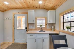 a kitchen with white cabinets and a sink and a door at Close to Trails Studio with Water Views in Wurtsboro
