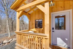 a tiny house with a porch and a white door at Close to Trails Studio with Water Views in Wurtsboro
