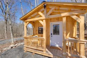 a small wooden cabin with a white door at Close to Trails Studio with Water Views in Wurtsboro