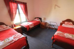 a bedroom with two twin beds and a window at Kerrellie Cottages 2, 4 & 8 Reid Street in Strahan