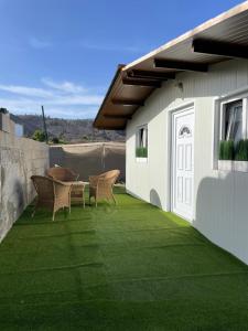 a patio with chairs and a table on a lawn at Small house in the nature in Granadilla de Abona