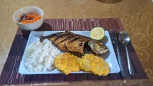 a plate of food with rice and fish and a lemon at Casa Tortuga in El Valle