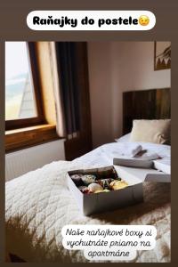 a box of cookies sitting on top of a bed at Apartmány Starý mlyn in Habovka +35 photos