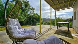 two chairs sitting on a porch with a table at Evasion verte - Villa 3 chambres à Rivière Pilote in Rivière-Pilote
