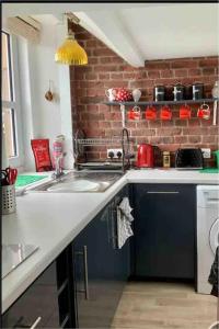a kitchen with a sink and a brick wall at Driftwood in Gourdon +42 photos