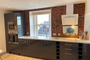 a kitchen with a counter top and a window at Driftwood in Gourdon